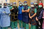 Group posing in scrubs and wearing masks