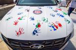 Hood of white Hyundai with colorful handprints