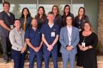 The UC Davis Health Home Infusion team, consisting of 11 members, smiling for a group photo outside their Rocklin base building. 