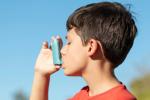 Boy breathing in from an inhaler.
