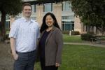 A man and woman post for a portrait outside the UC Davis MIND Institute 