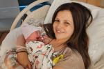 Woman in hospital bed holding newborn