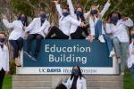 Medical students wearing masks and white coats with arms in the air