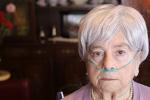 Senior woman using nasal breathing aid at home