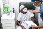 Nurse in blue scrubs giving comfort to a patient sitting in a chair in a doctor's office