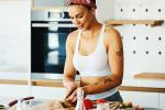 Young fit woman preparing meal in the kitchen.