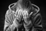 An old woman covering her face.