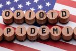 Elevated view of Opioid Epidemic text on wooden cork over American flag