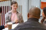 A group of four adults, some with disabilities, gathers at a round table in discussion. 