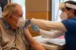 elderly man receiving vaccine in arm