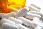 Open bottle of prescription medication with pills pouring out