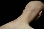 Rear view of sorrowful man with bald head and face hidden