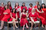 Female physicians wearing red dresses sitting in chairs