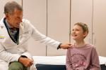 Photo of doctor with patient in exam room.