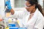 Female scientist looking through a microscope in a lab