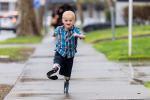 Boy with prosthetic legs running on a sidewalk