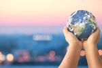 Hands holding a globe with a blurred background of vehicles