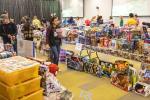 A handful of people peruse through a conference room where hundreds of new toys crowded the tables and floor.