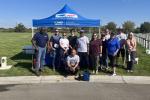 Volunteers stand in front of booth at cemetery 