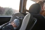 Man drives while child is in car seat behind him