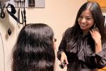 A woman with long dark hair and stethoscope around her neck converses with a female patient in a clinic exam room