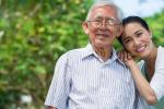 Portrait of happy senior man and his adult daughter leaning on his shoulder