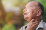 Older male patient holding his throat