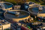 An aerial view of a water treatment plant featuring three large water storage tanks