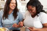 Two women smiling and eating a healthy meal