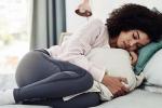 Woman lying in bed in discomfort