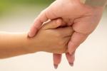 Woman holds hand of child