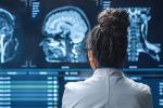 Black female neuroscientist looking at TV screen, analyzing brain scan MRI Images