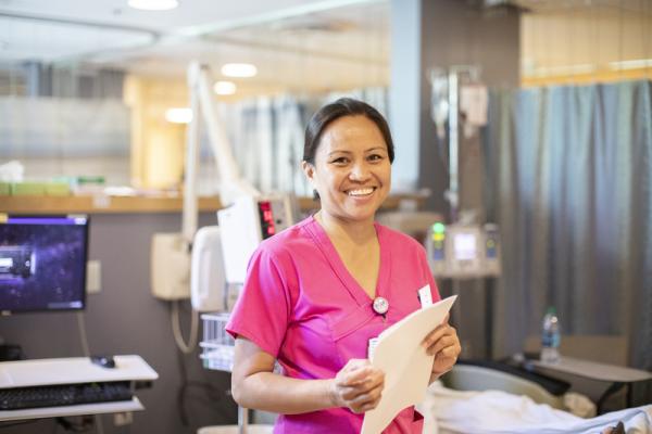 UC Health nurse in scrubs standing in a hospital room