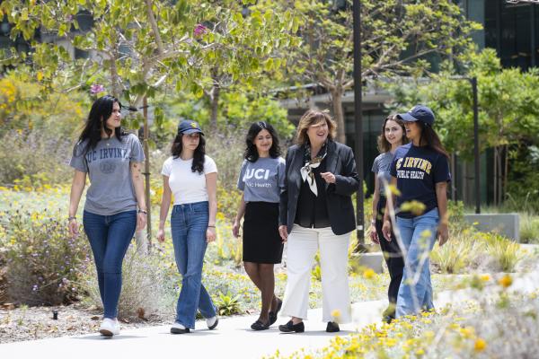 founding dean of UC Irvine School of Public Health walking with students outside