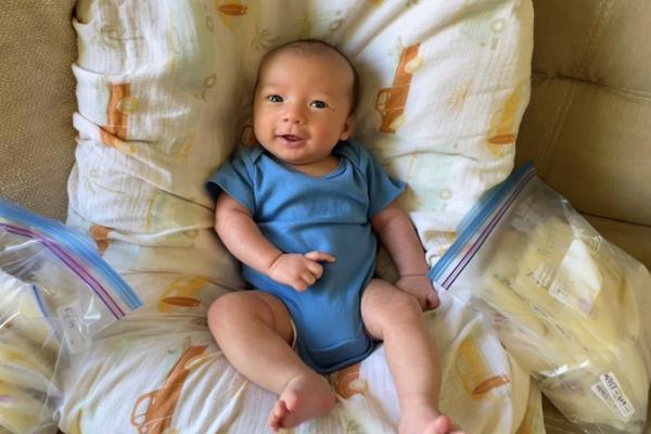 baby smiling next to donated milk