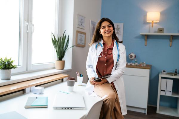 image of a physician in a white coat sitting in a doctor's office