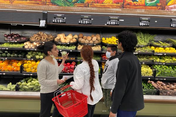Photo of a physician in front of vegetables teaching patients how to choose food effectively 