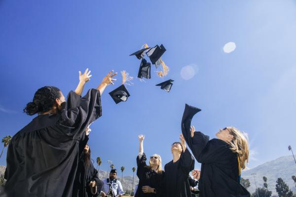 image of students throwing their graduation caps in the air