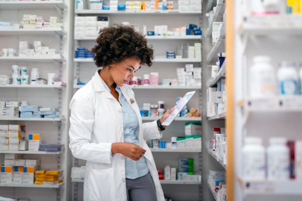 pharmacist in a white coat looking down at medications
