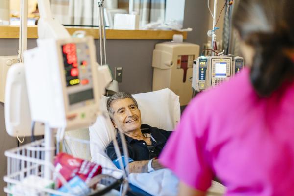 Patient in a bed with a health professional at a UC hospital