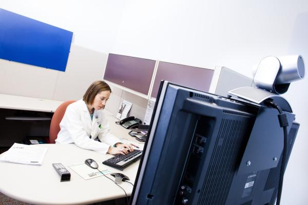 UC physician sitting at a desk for a virtual care visit