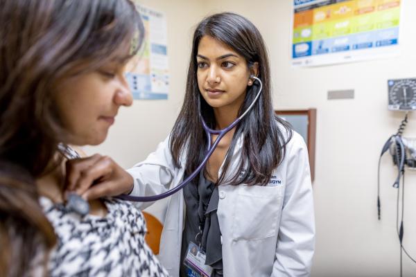 UCI Health clinician examining a patient with stethoscope