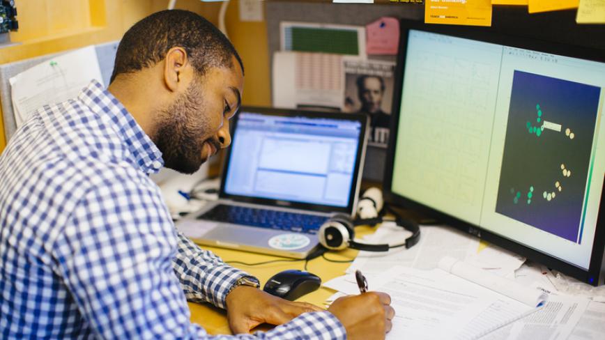 medical research patient data UC researcher sitting at desk in front of a computer