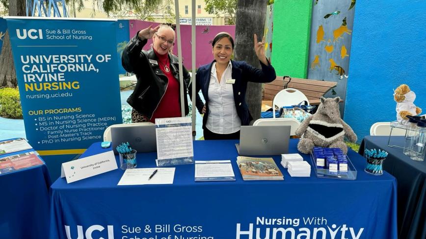 two women at a table highlighting the UCI Sue & Bill Gross School of Nursing. 