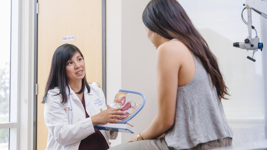 provider speaking to student holding a health model