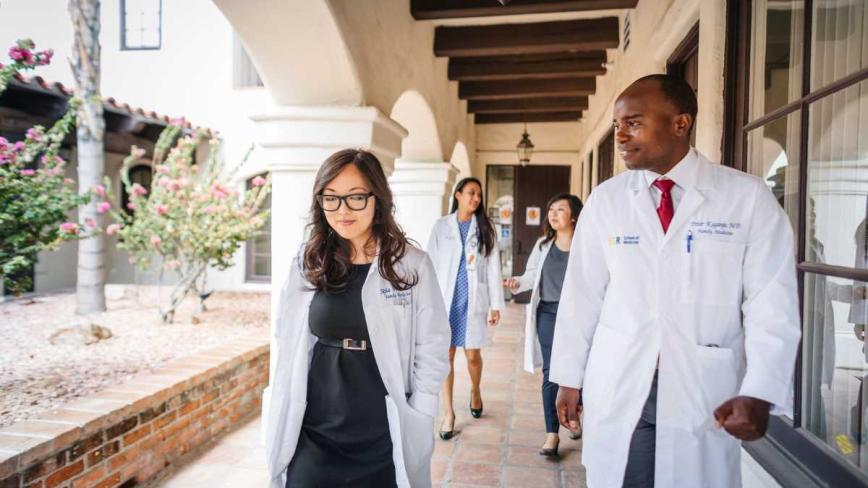 group of medical students in white coats walking