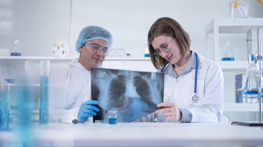 two clinicians looking at an Xray of a lung 
