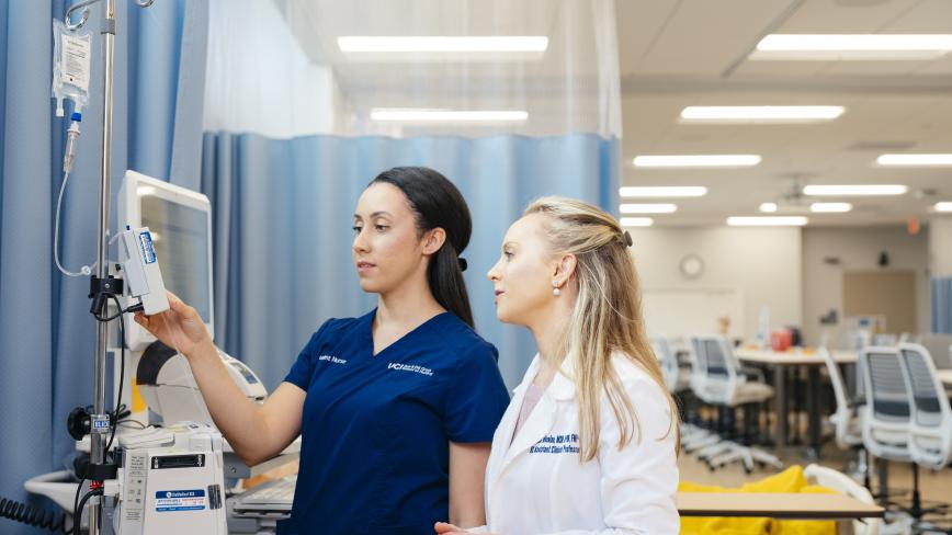 Simulated training between a student and faculty in a white coat