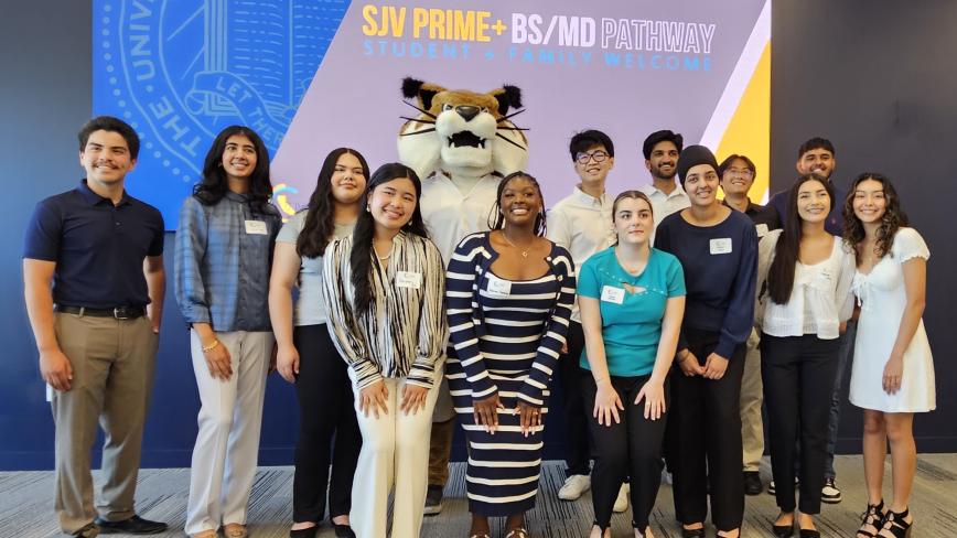photo of students with the UC Merced mascot in front of a sign that says SJV PRIME+ BS/MD pathway