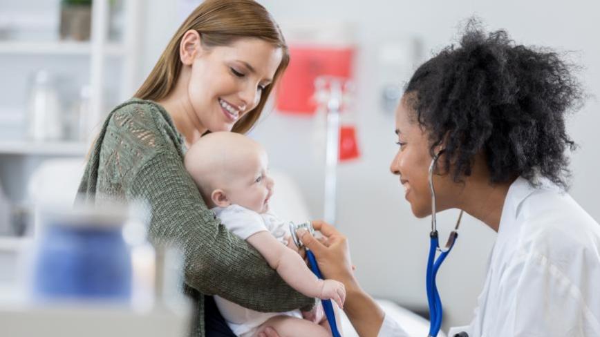 Person holding a baby with health care provider